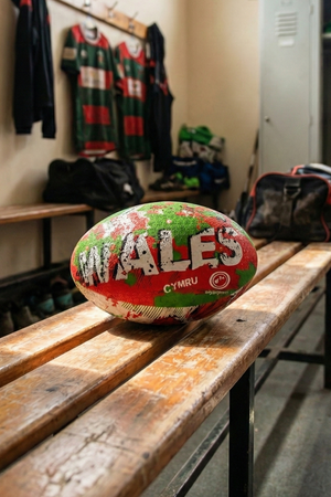 Red, green and white Optimum Wales rugby ball with WALES CYMRU print on a changing-room bench - Optimum