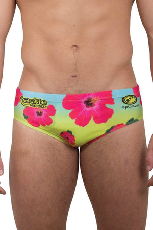 Optimum Tackle Trunks swim brief in neon hibiscus floral print, front view on male model with tackle trunks logo - Optimum