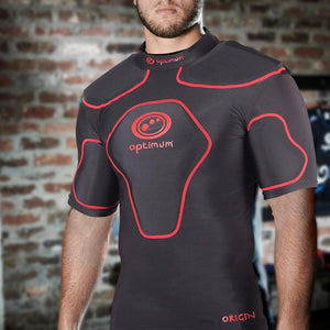 Man wearing black Optimum Origin rugby protective top with red trim and logo, brick wall setting - Optimum