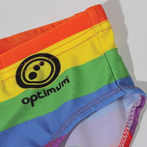 Optimum Tackle Trunks swim brief, close-up of hip with black Optimum logo on rainbow stripe print - Optimum