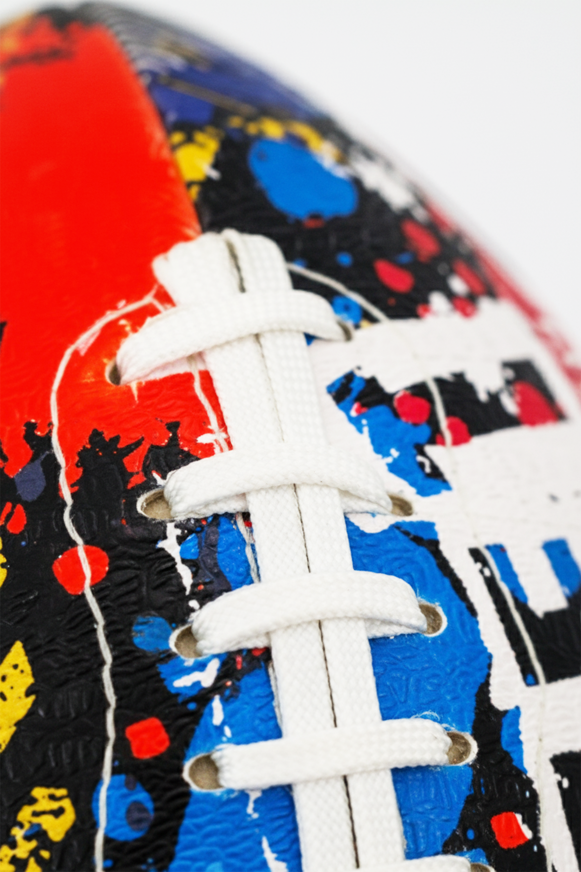 Macro close-up of white laces on graffiti-print Optimum Street football - Optimum