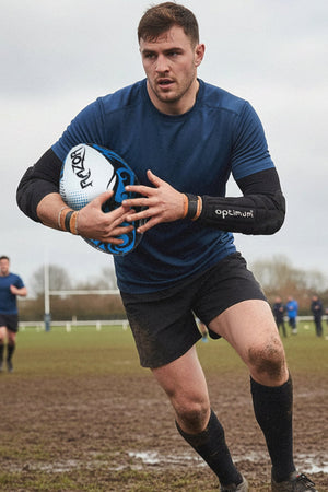 Female rugby player in green and black hooped jersey wearing black Optimum forearm guard at sunset - Optimum