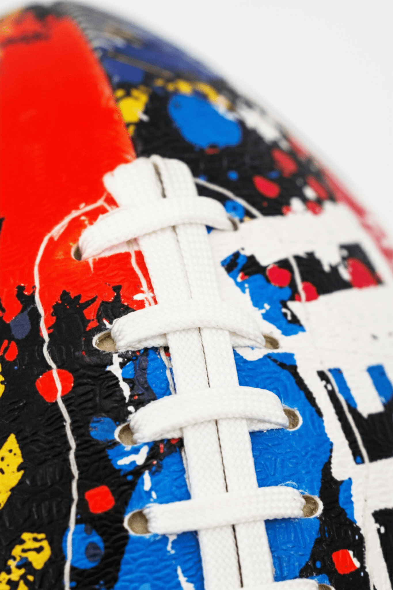 Macro close-up of white laces on graffiti-print Optimum Street football - Optimum