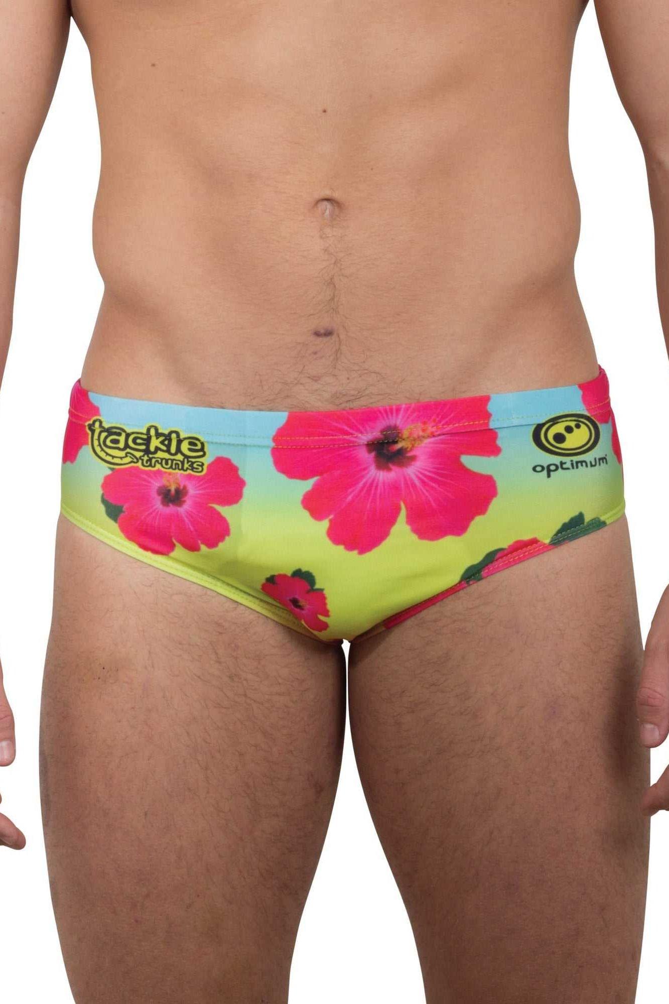 Optimum Tackle Trunks swim brief in neon hibiscus floral print, front view on male model with tackle trunks logo - Optimum