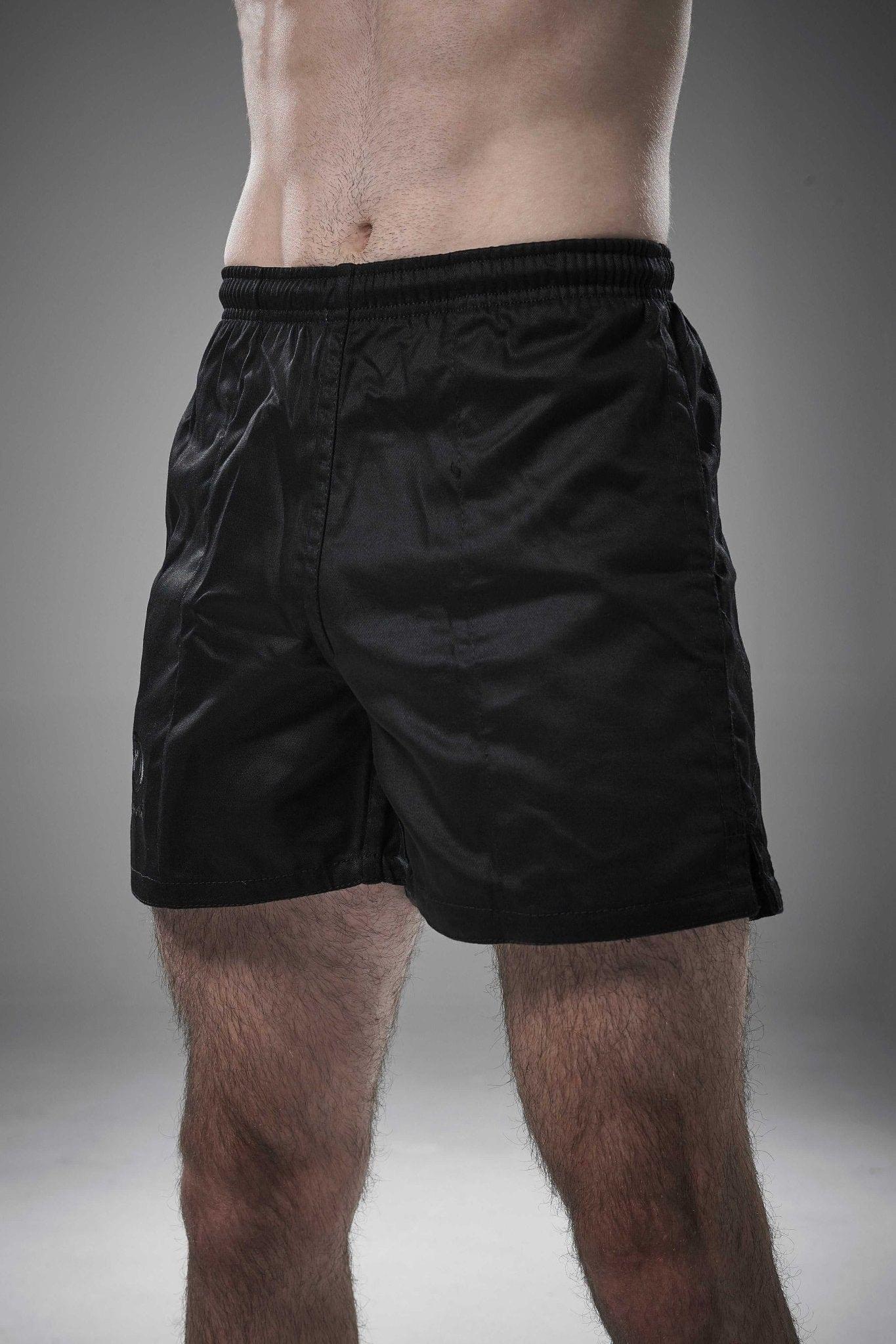 Man wearing black Optimum Auckland rugby shorts, front view on grey studio background - Optimum