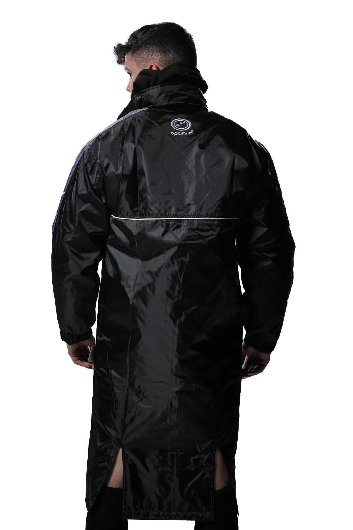 Man wearing long black Optimum sideline sub jacket, back view with reflective piping, on white - Optimum