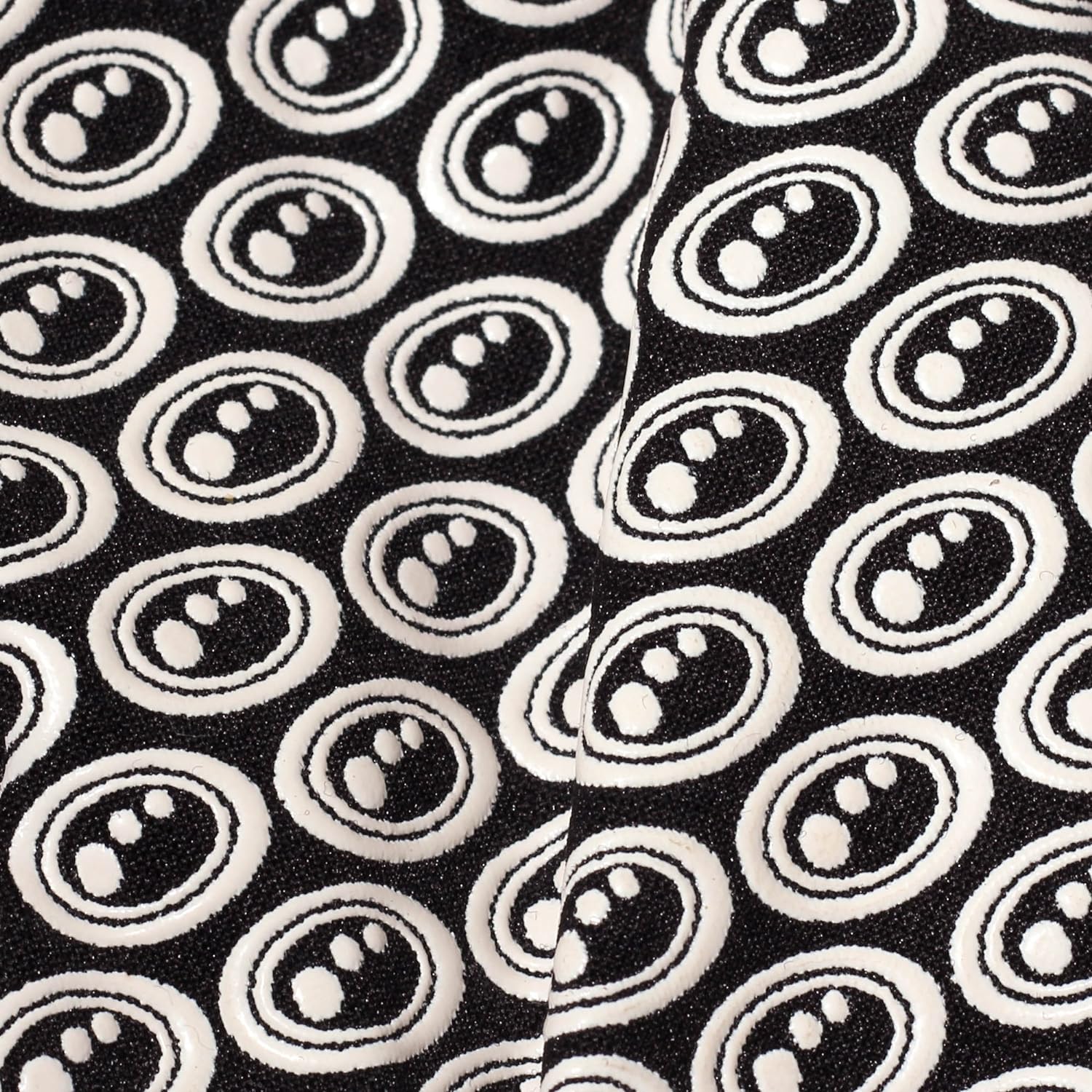 Extreme close-up of black Optimum Stik Mits glove fabric showing raised white oval silicone grip print - Optimum