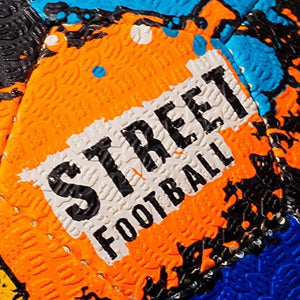 Close-up of black Optimum street football surface with orange splatter and Street Football text - Optimum