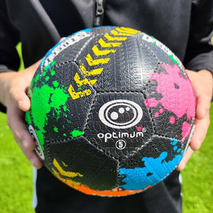 Person holding black size 5 Optimum street football with green, pink and blue splatter print - Optimum