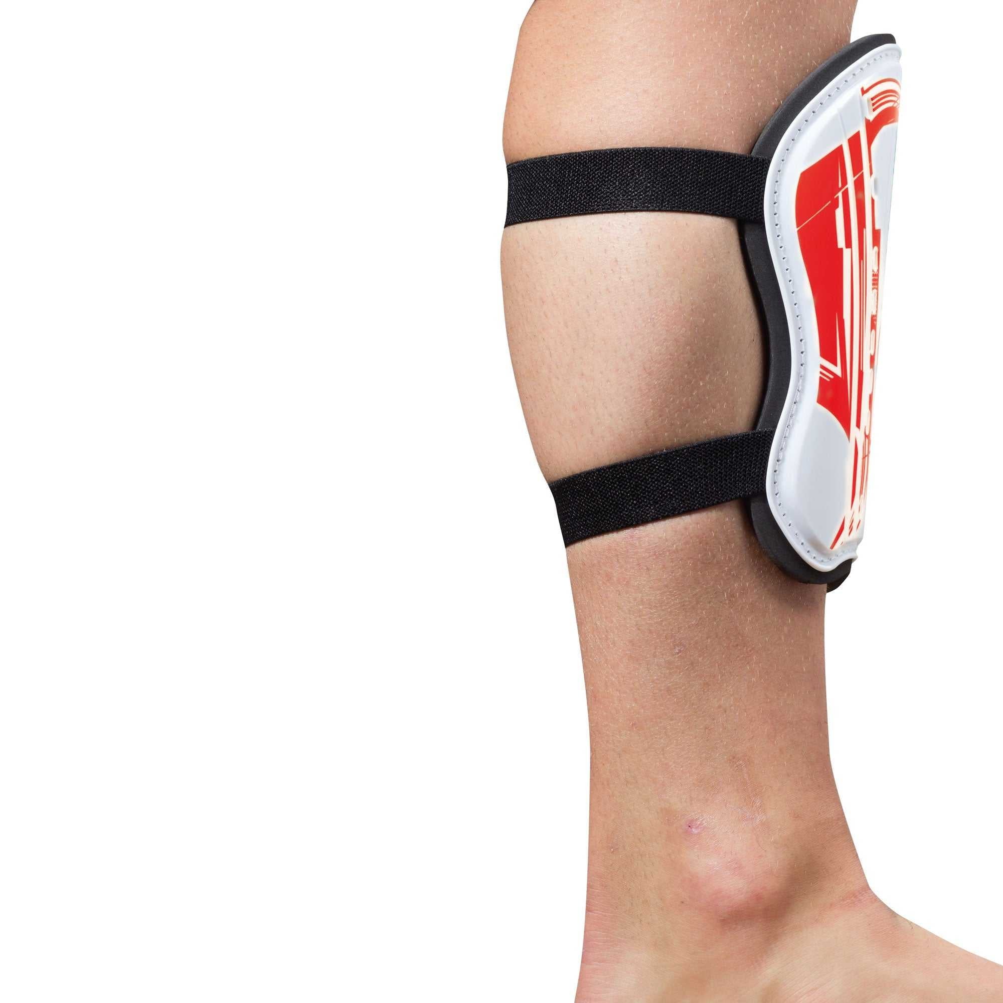 White and red Optimum Velocidade shin guard with two black elastic straps on lower leg, side view on white - Optimum