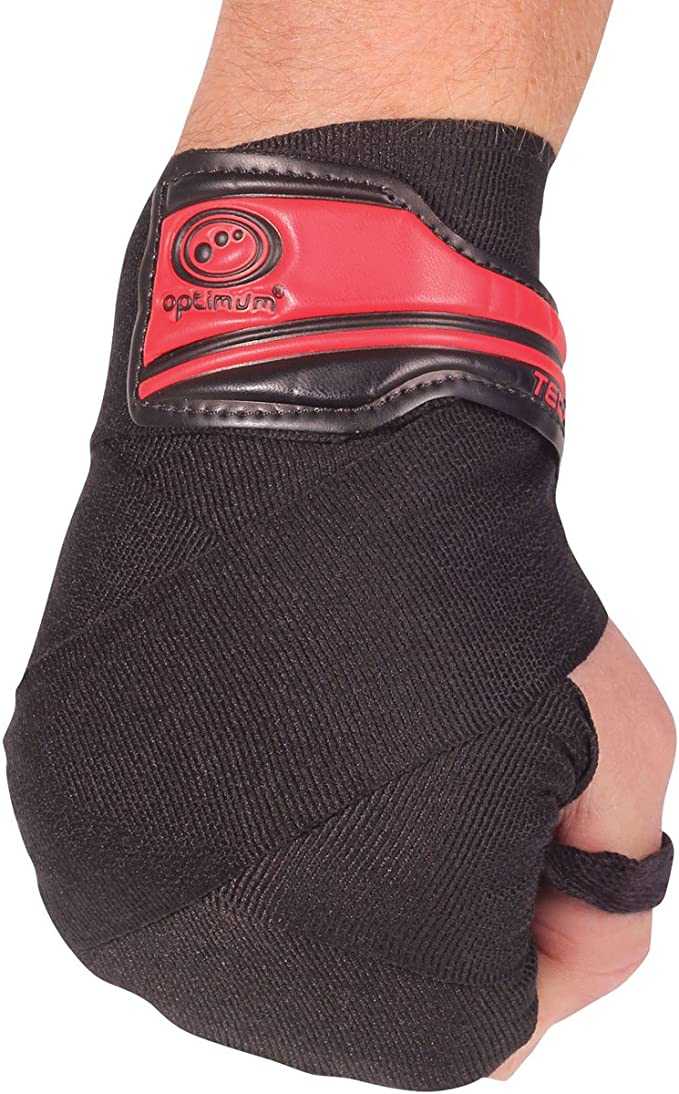 Fist wearing black Optimum Tech Pro boxing wrap with red gel knuckle pad, angled view on white - Optimum